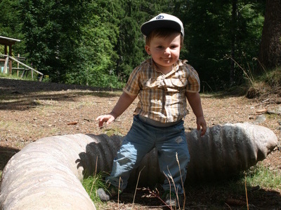 Kind sitzt auf einem nachgebauten, berdimensionalen Riesenregenwurm