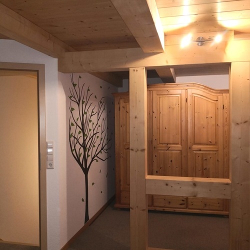 Blick durch Holzbalken, als Raumteiler, auf einen großen Holzschrank - Blick durch Holzbalken, als Raumteiler, auf einen großen Holzschrank -