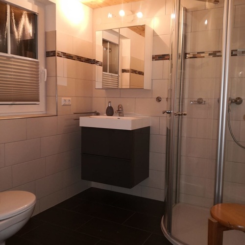 Badezimmer mit Eckdusche, Waschbecken und Toilette sowie einem Fenster - Badezimmer mit Eckdusche, Waschbecken und Toilette sowie einem Fenster -