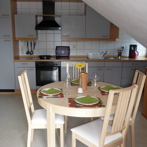 runder Esstisch mit vier Stühlen im Hintergrund die Küchenzeile - runder Esstisch mit vier Stühlen im Hintergrund die Küchenzeile -